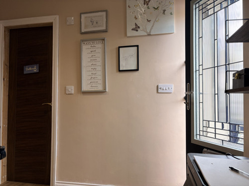 Framed prints on the therapy room wall, beside the door through to the bathroom